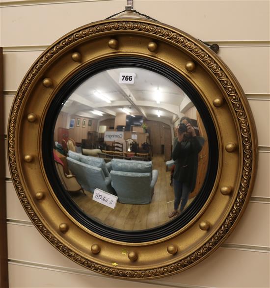 A gilt framed convex wall mirror, W.52cm
